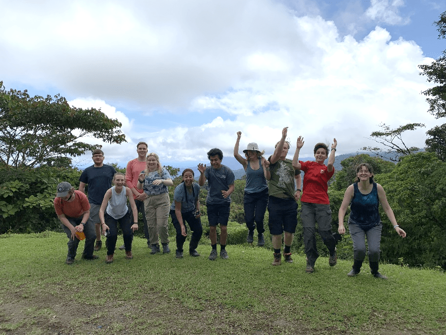 Ecology students on a hill in Costa Rica, jumping. Photo: Amanda Rugenski.