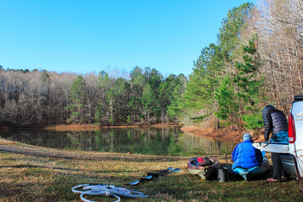 Lab manager Kate Galbraith and PhD student Daniel Suh prepare kayaks for sampling algal blooms and host-parasite dynamics at Deer Pond on a clear winter day. Photo: Catherine Campbell.