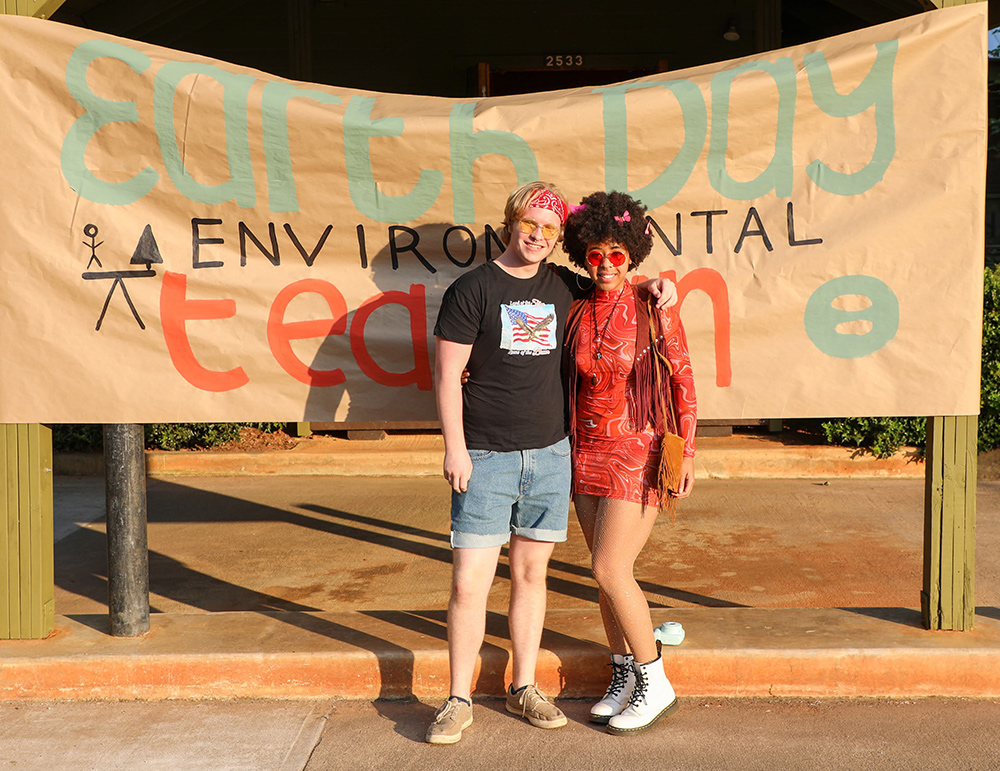 Rock stars stand in front of the Earth Day Environmental Teach-In banner. Photo: Ben Taylor.