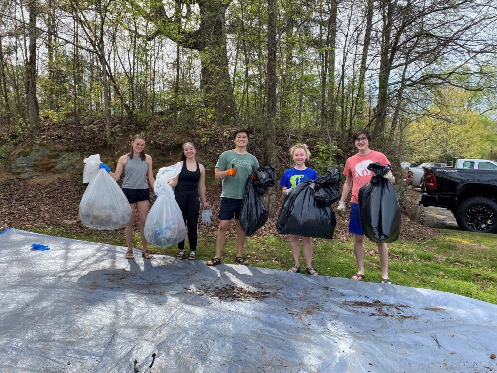 students pose with trashbags