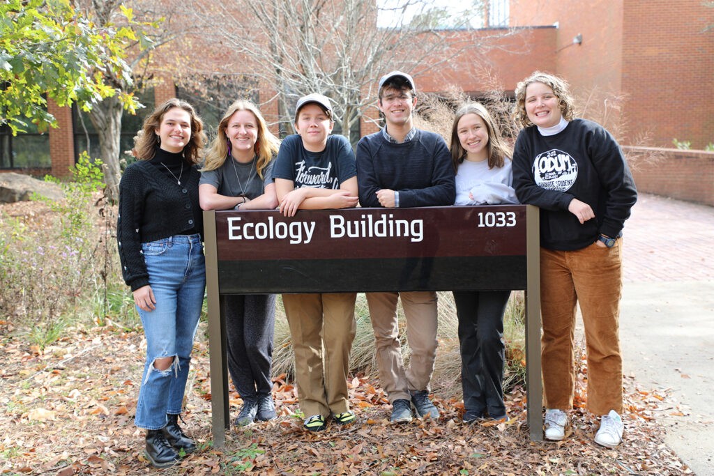 students pose in front of ecology sign